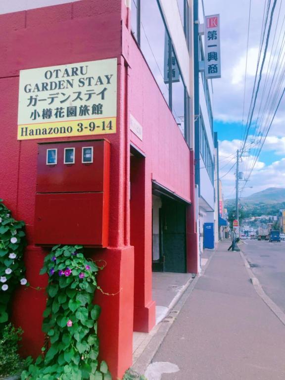 a red building with a sign on the side of it at Otaru Garden Stay in Otaru