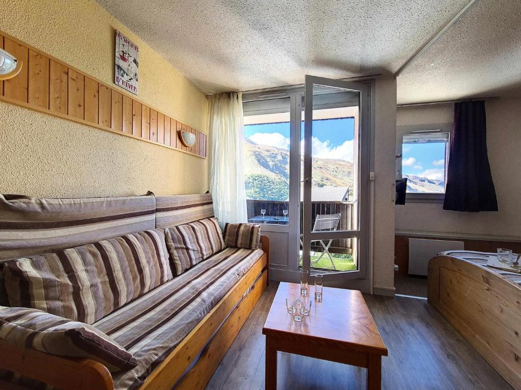 un salon avec un canapé et une table dans l'établissement Résidence Villaret - Studio atypique avec beaucoup de rangement MAE-2694, aux Menuires