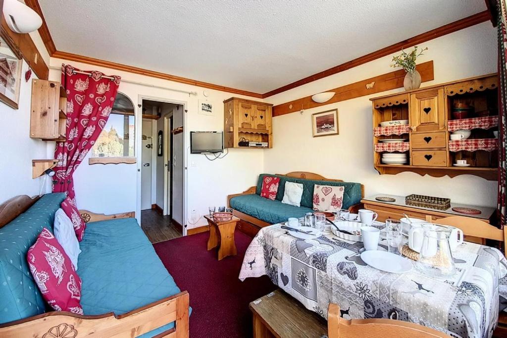 Cette caravane comprend un salon avec une table et un canapé. dans l'établissement Résidence Chaviere - Studio agréable · Au pieds des pistes · Balcon nord MAE-2714, aux Menuires