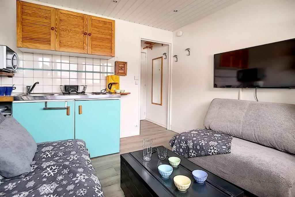 un salon avec un canapé et une cuisine dans l'établissement Résidence Alpages - Studio agréable · Au pieds des pistes MAE-2864, aux Menuires