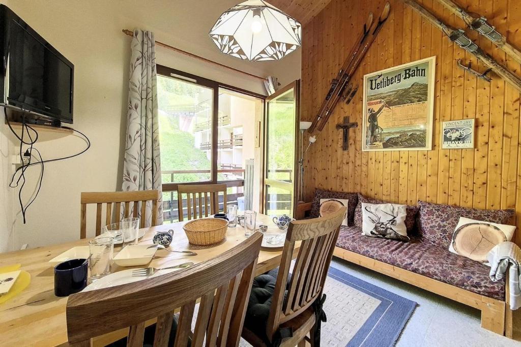 une salle à manger avec une table et un canapé dans l'établissement Résidence Argousier - Appartement fonctionnel · Proche des pistes · Balcon · Garage couvert MAE-3264, aux Menuires