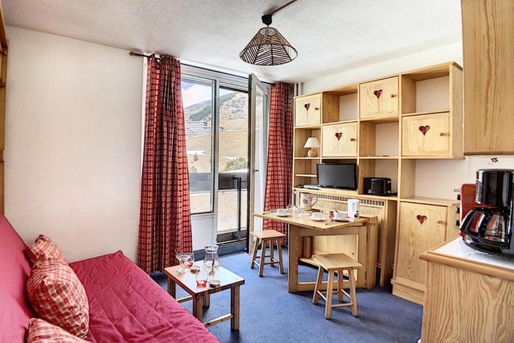 un salon avec un canapé et une table et une cuisine dans l'établissement Résidence Dorons - Studio agréable · Centre station MAE-3404, aux Menuires