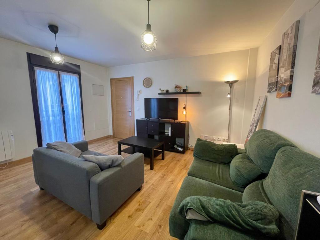 希洪Apartamento casco histórico Gijón的客厅里有一张绿色的沙发和一张桌子