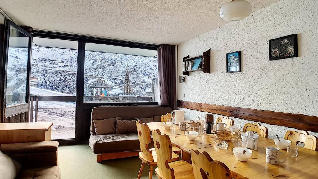 une pièce avec une table, des chaises et un canapé dans l'établissement Résidence Aravis - Appartement spacieux · Départ et retour ski aux pieds · Balcon vue montagnes MAE-3704, aux Menuires