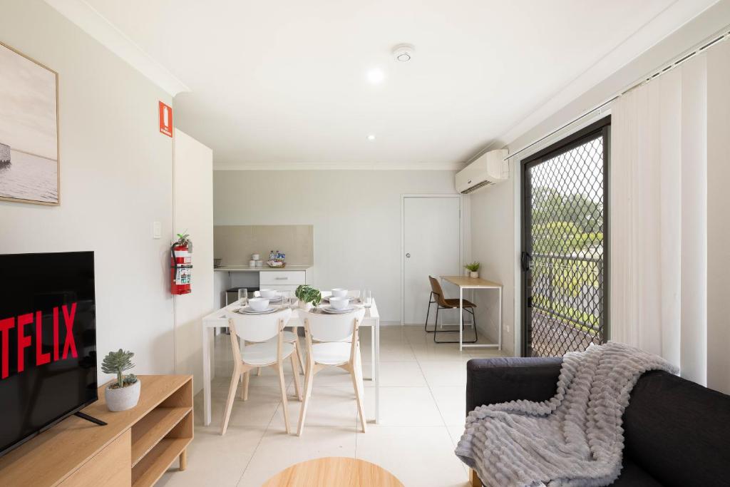 a living room with a couch and a table at Smart Suites Self Check-in Apartments - Freney Park Disk Golf Course in Brisbane