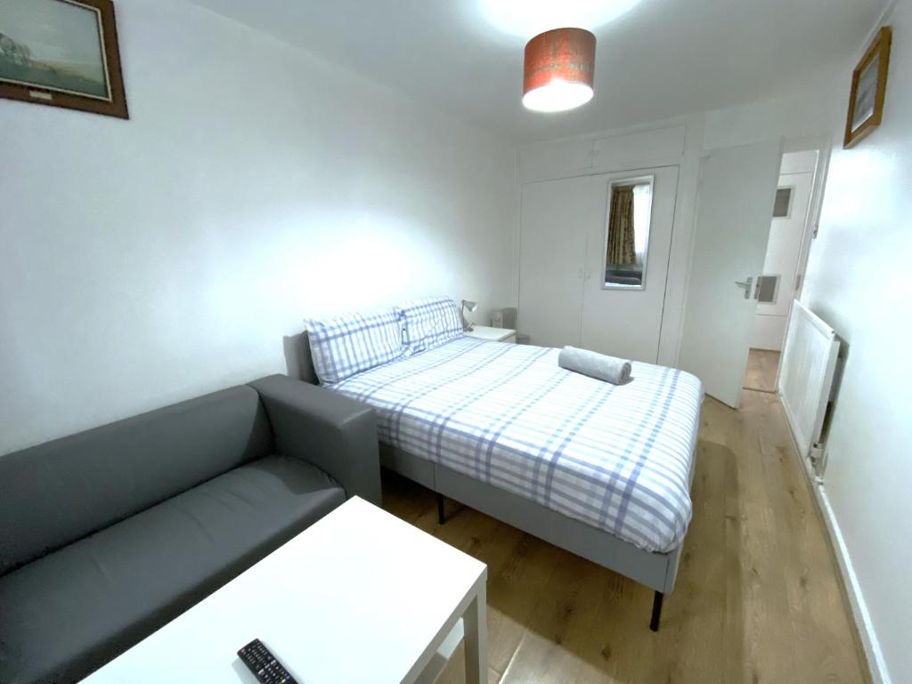 a small room with a bed and a couch at Laret Guest House in London