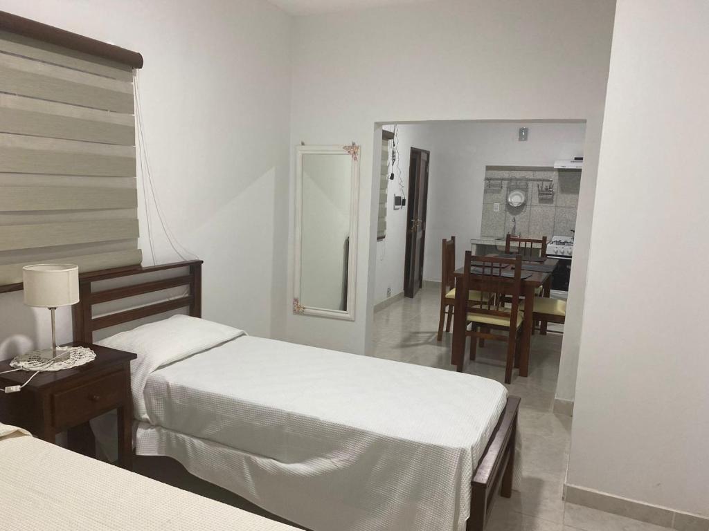 a bedroom with two beds and a dining room at Departamentos Ohana in San Ramón de la Nueva Orán