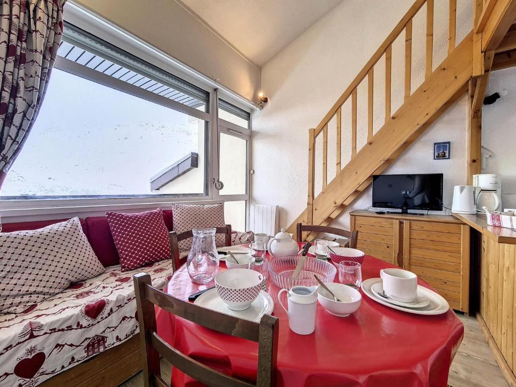 une salle à manger avec une table avec une nappe rouge dans l'établissement Résidence Asters C1 - Appartement confortable · Proche des pistes · Place de parking extérieure MAE-4241, aux Menuires