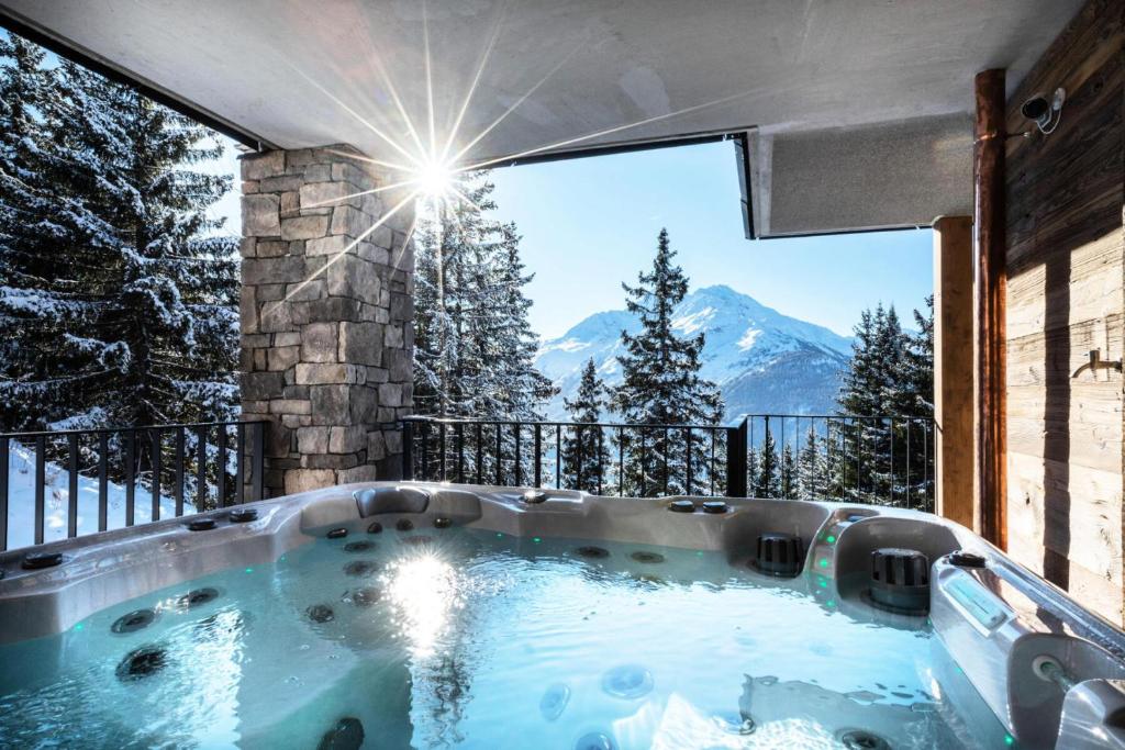 une baignoire jacuzzi avec vue sur les montagnes dans l'établissement Résidence OrÉe Du Bois - APPARTEMENT N°4 L'OREE DU BOIS MAE-9651, à Montvalezan