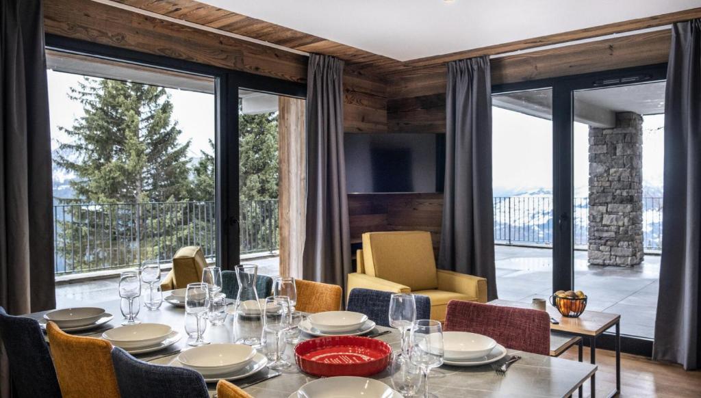 une salle à manger avec une table, des chaises et des fenêtres dans l'établissement Résidence OrÉe Du Bois - APPARTEMENT N°2 L'OREE DU BOIS MAE-9721, à Montvalezan