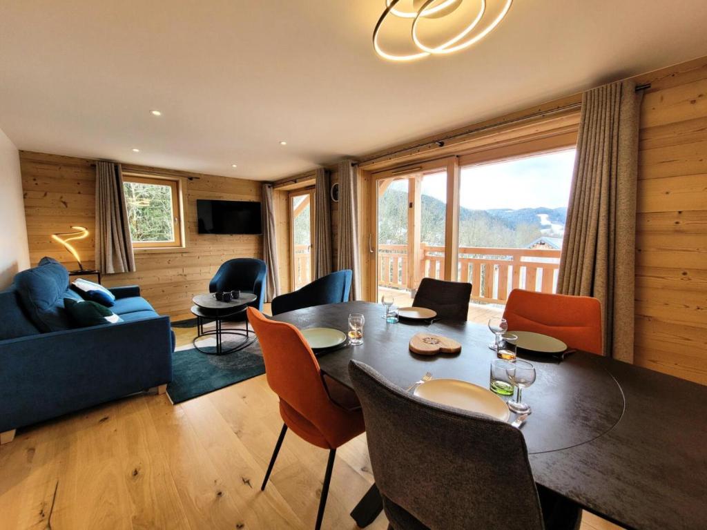 un salon avec une table, des chaises et un canapé dans l'établissement Résidence Le Clos D'arsene - Appartement lumineux avec terrasse MAE-5601, aux Gets