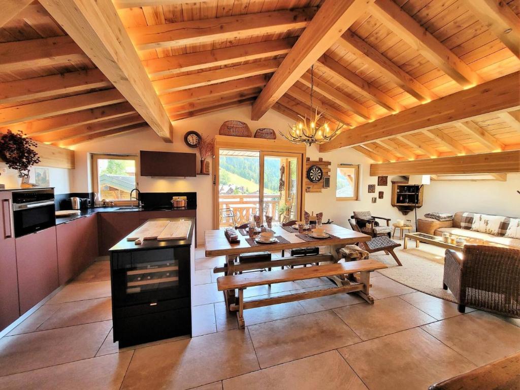 une cuisine et un salon avec une table et une salle à manger dans l'établissement Résidence Ambrocella - Appartement de charme sous les toits MAE-2301, aux Gets