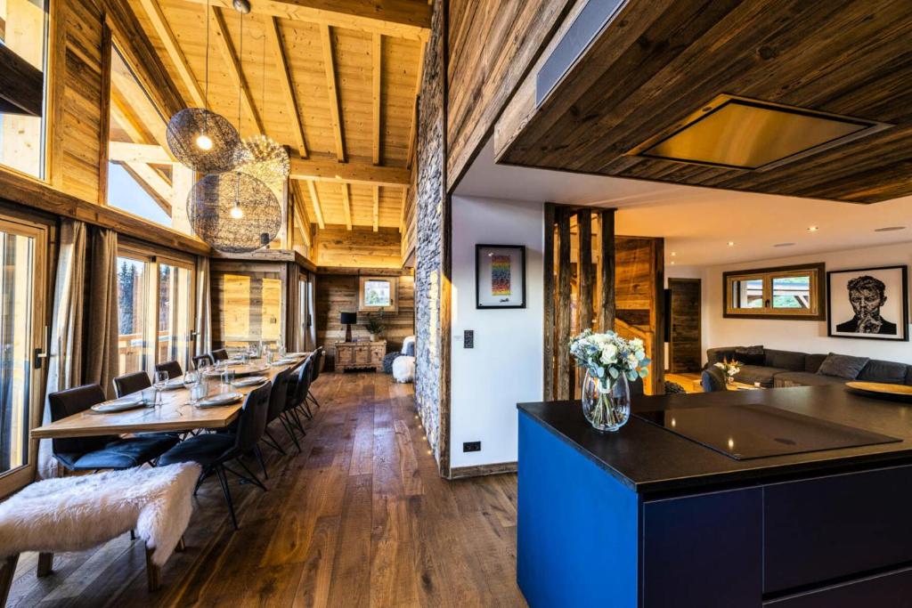 Il comprend un salon doté de plafonds en bois et une salle à manger. dans l'établissement Chalet Nyumbani - Exceptionnel : Chalet prestigieux, belles finitions, proche pistes de ski MAE-2361, aux Gets