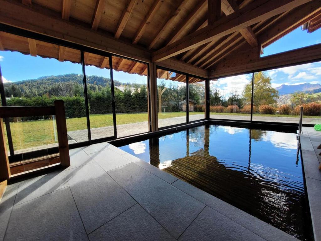 - une piscine dans une maison avec vue sur les montagnes dans l'établissement Chalet Les Sauvageons - Grand luxe au cœur des Gets, avec piscine & hammam MAE-2431, aux Gets