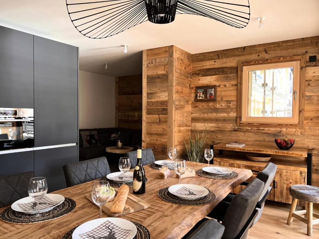 une salle à manger avec une table et des chaises en bois dans l'établissement Résidence Essentiel - Appartement de standing, esprit cosy, large terrasse MAE-2531, aux Gets