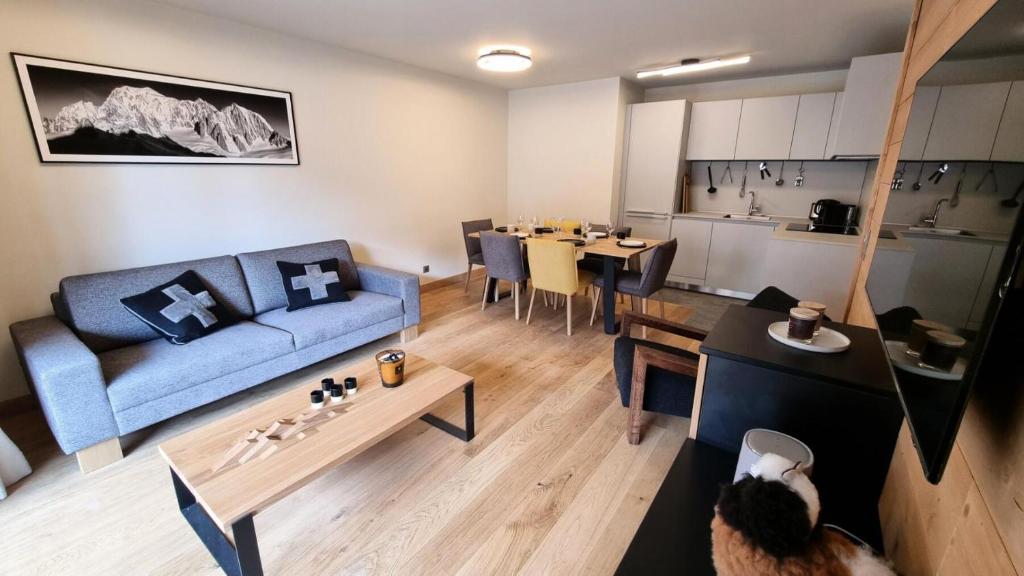 un salon avec un canapé bleu et une table dans l'établissement Résidence Le Stella - Appartement de standing au cœur du village MAE-2571, aux Gets