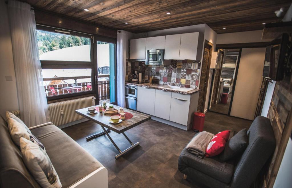 un salon avec un canapé et une table dans l'établissement Résidence Ranfolly - Studio au centre du village MAE-2651, aux Gets
