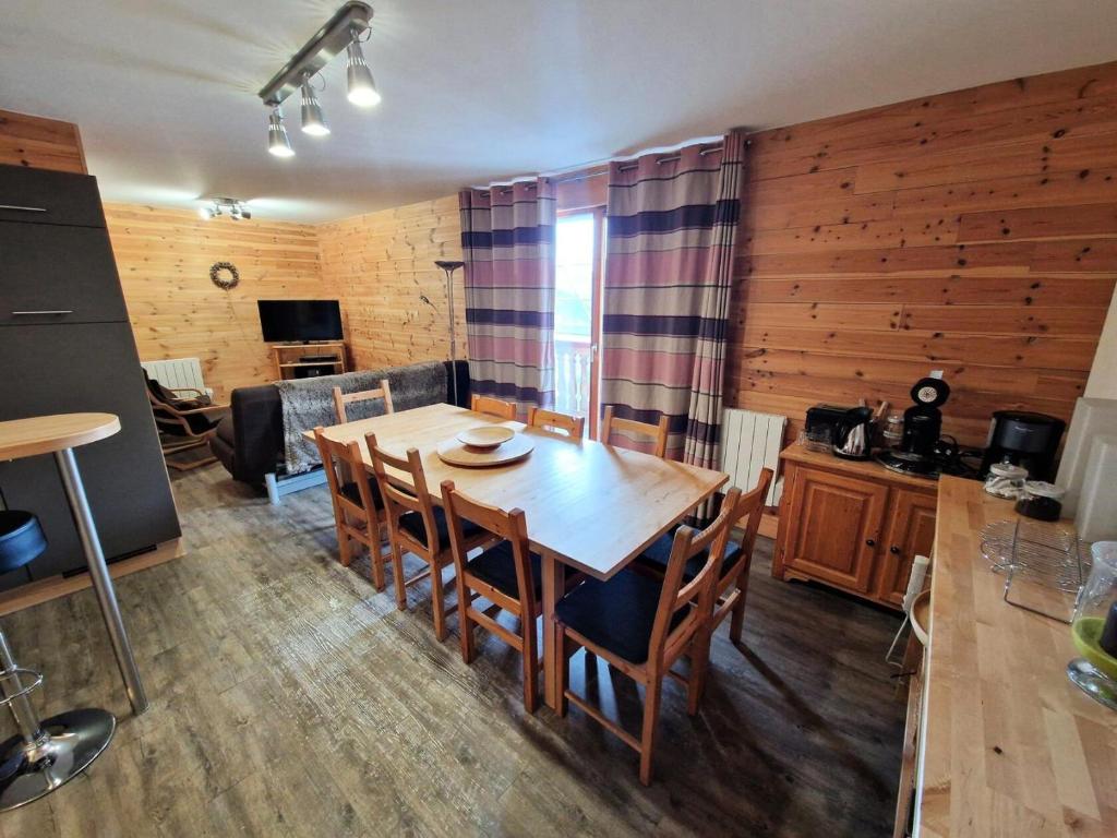 une cuisine et une salle à manger avec une table et des chaises en bois dans l'établissement Résidence Grand Argentier - 3 pièces +cabine 8 /10personnes coeur station 55m² MAE-7171, à Modane
