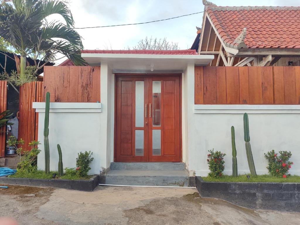 une maison avec une porte rouge et une clôture dans l'établissement Octopus Homestay, à Uluwatu