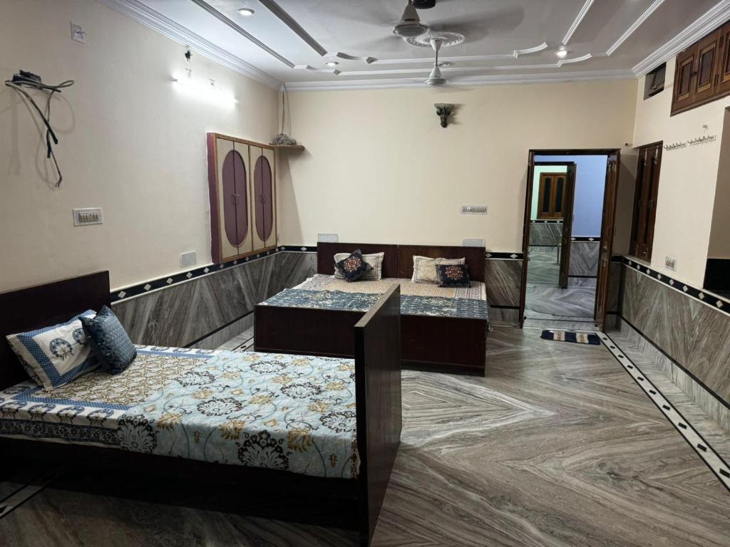 a room with two beds and a couch at Rose Merry Guesthouse in Bikaner