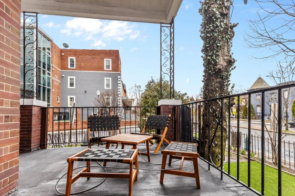 a balcony with two chairs and two tables on it at 3-BR Historic Home Nestled Btw Petworth & CoHi in Washington, D.C.