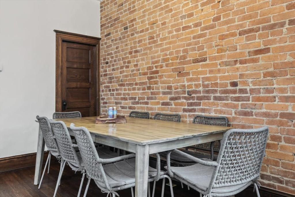 a wooden table with chairs and a brick wall at 3-BR Historic Home Nestled Btw Petworth & CoHi in Washington, D.C.