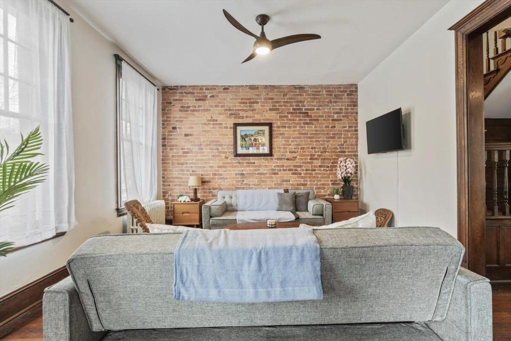 a living room with a couch and a ceiling fan at 3-BR Historic Home Nestled Btw Petworth & CoHi in Washington, D.C.