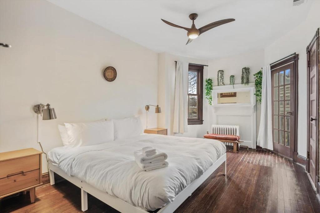 a bedroom with a white bed with a ceiling fan at 3-BR Historic Home Nestled Btw Petworth & CoHi in Washington, D.C.
