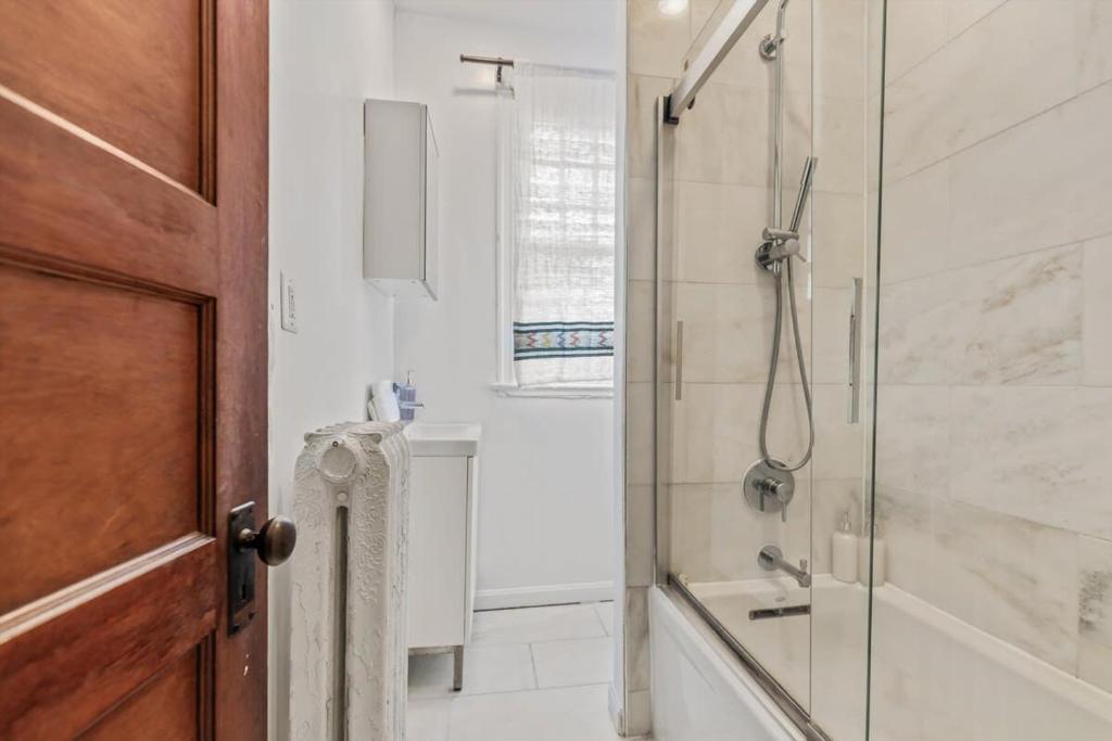a bathroom with a shower and a glass shower backdoor at 3-BR Historic Home Nestled Btw Petworth & CoHi in Washington, D.C.