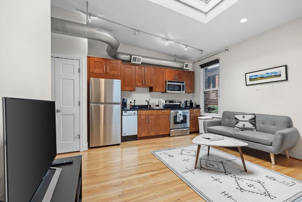 a kitchen and living room with a couch and a table at Logan Circle Carriage House 1b-1b Central & Bright in Washington, D.C.
