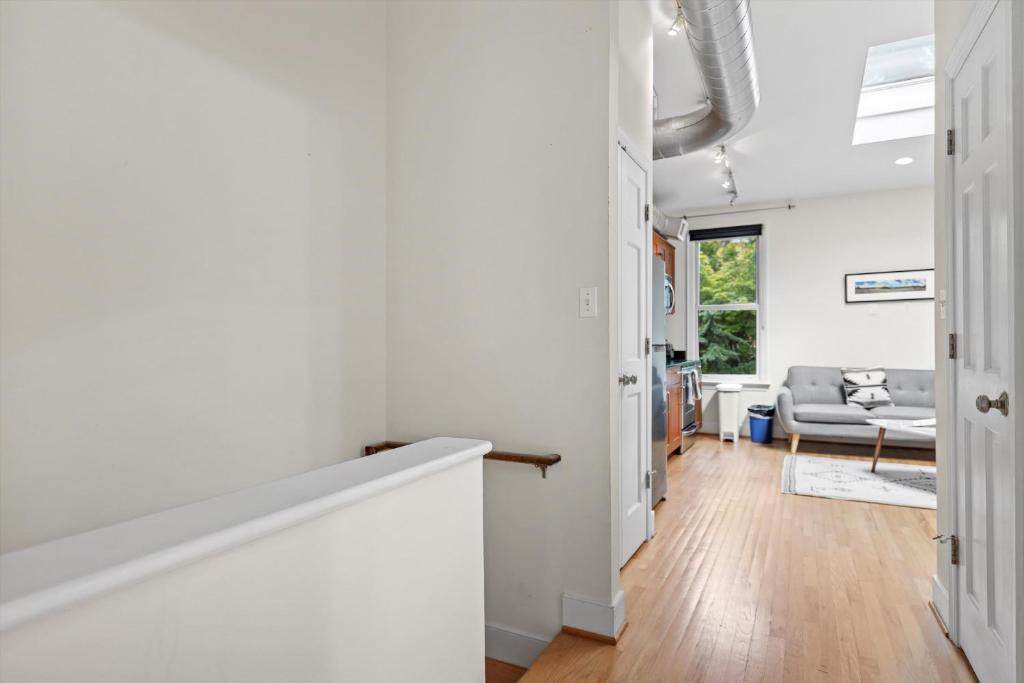 a living room with white walls and wood floors at Logan Circle Carriage House 1b-1b Central & Bright in Washington, D.C.