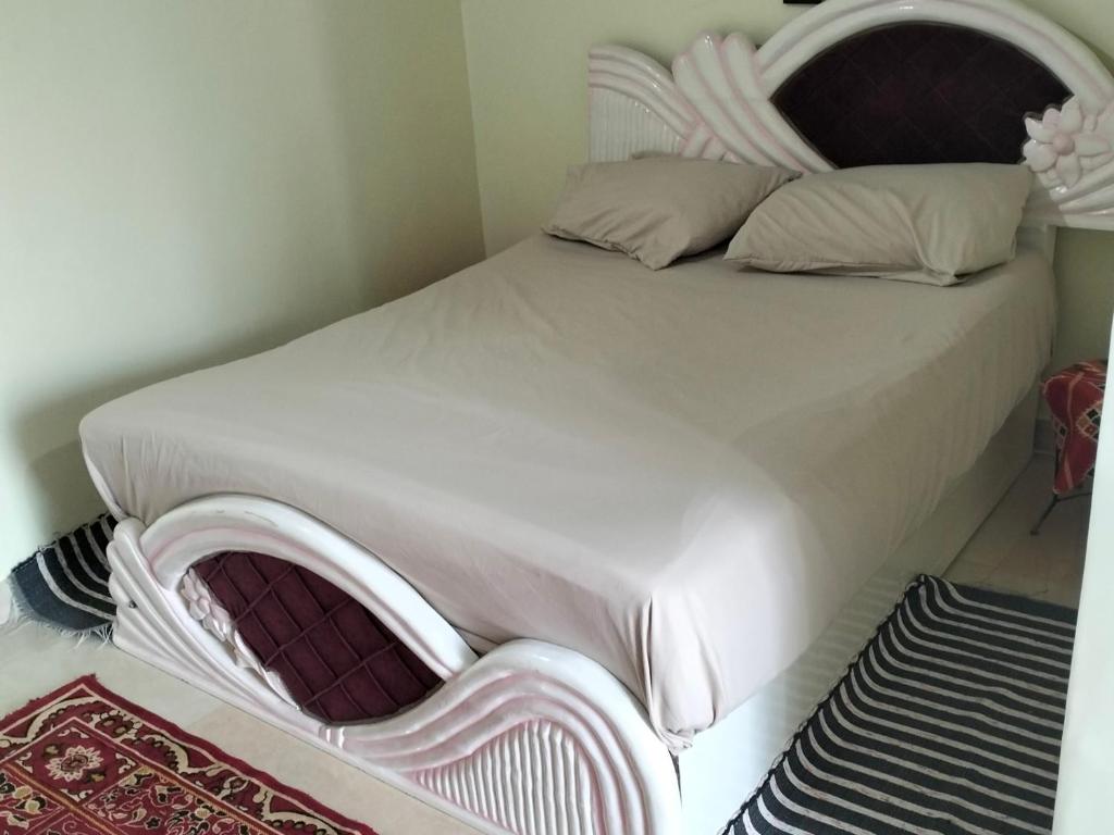 a bedroom with a white bed with a headboard at Roma House in Aswan