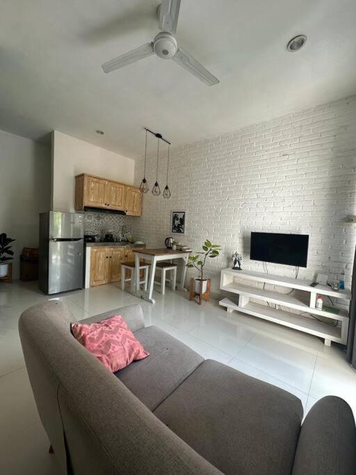 a living room with a couch and a kitchen at Permata Tojan Blok A3 in Ubud