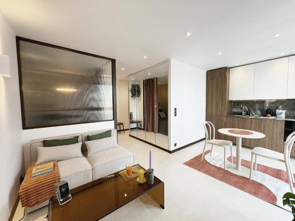 un salon avec un canapé et une table dans l'établissement TheSuite - Parmentier - MONTHLY RENTAL ONLY, à Paris