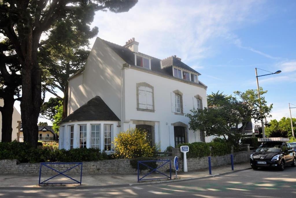 une maison blanche avec une voiture garée devant elle dans l'établissement La Villa Marie Vue imprenable, à Carnac