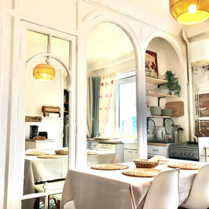 - une cuisine avec une table, des chaises et un miroir dans l'établissement Hyper centre dans ancien palace face aux thermes, à Mont-Dore