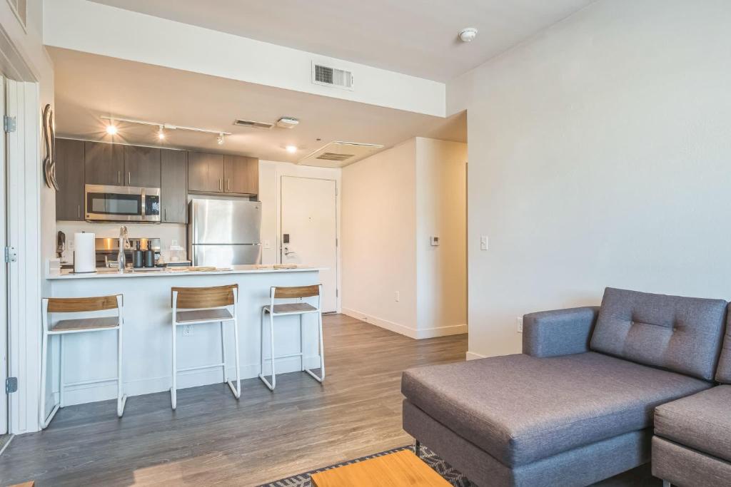 a living room with a couch and a kitchen at Chic and Modern Getaway with Gym 5 Min to Downtown in Boise