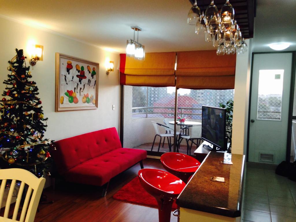 una sala de estar con un árbol de Navidad y un sofá rojo en Apartamento Castilla, en Viña del Mar