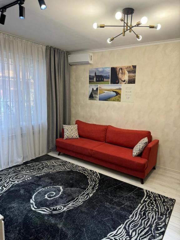 a living room with a red couch and a black rug at Apartment in Airport in (( Turksib ))