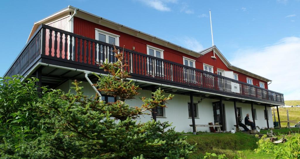 a red and white house with a balcony at Hótel Djúpavík in Djupavik