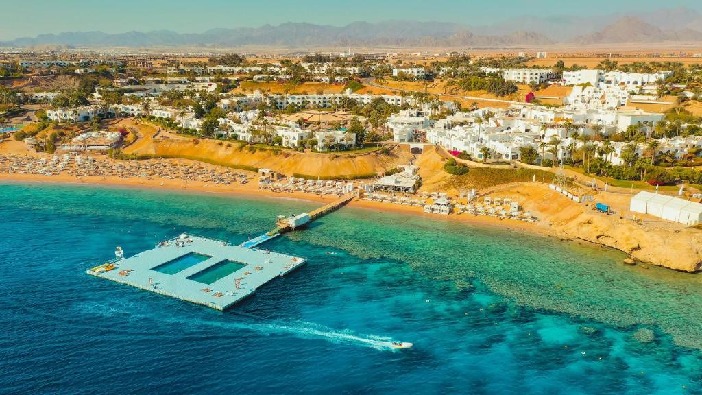 a boat in the water next to a beach at Domina Coral Bay Resort, Diving , Spa & Casino in Sharm El Sheikh