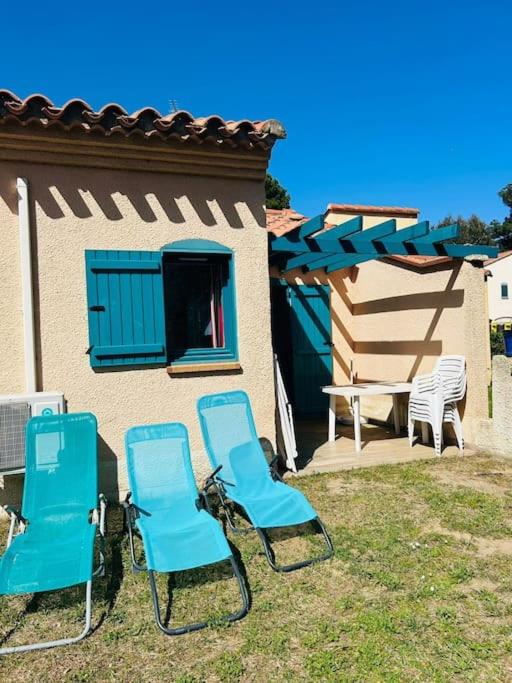 3 chaises bleues et une table devant une maison dans l'établissement Charmante maisonnette, à Argelès-sur-Mer