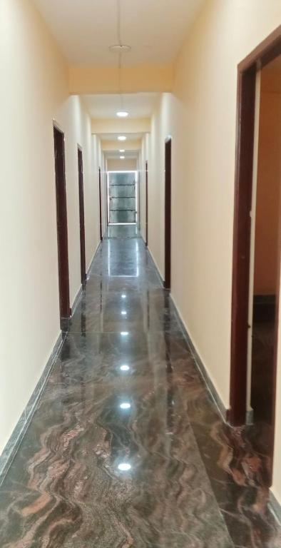 a hallway with a marble floor in a building at LJ Rooms in Pākkam