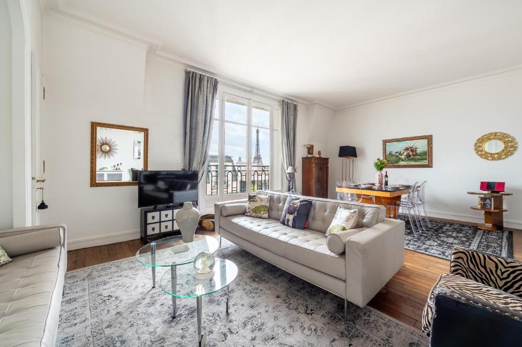 un salon avec un canapé et une table dans l'établissement Champs Elysées I Vue sur Tour Eiffel & Spacieux, à Paris
