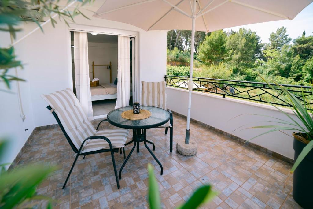 a patio with a table and chairs and an umbrella at The Rooftop of Apartments Lungo Mare in Ulcinj