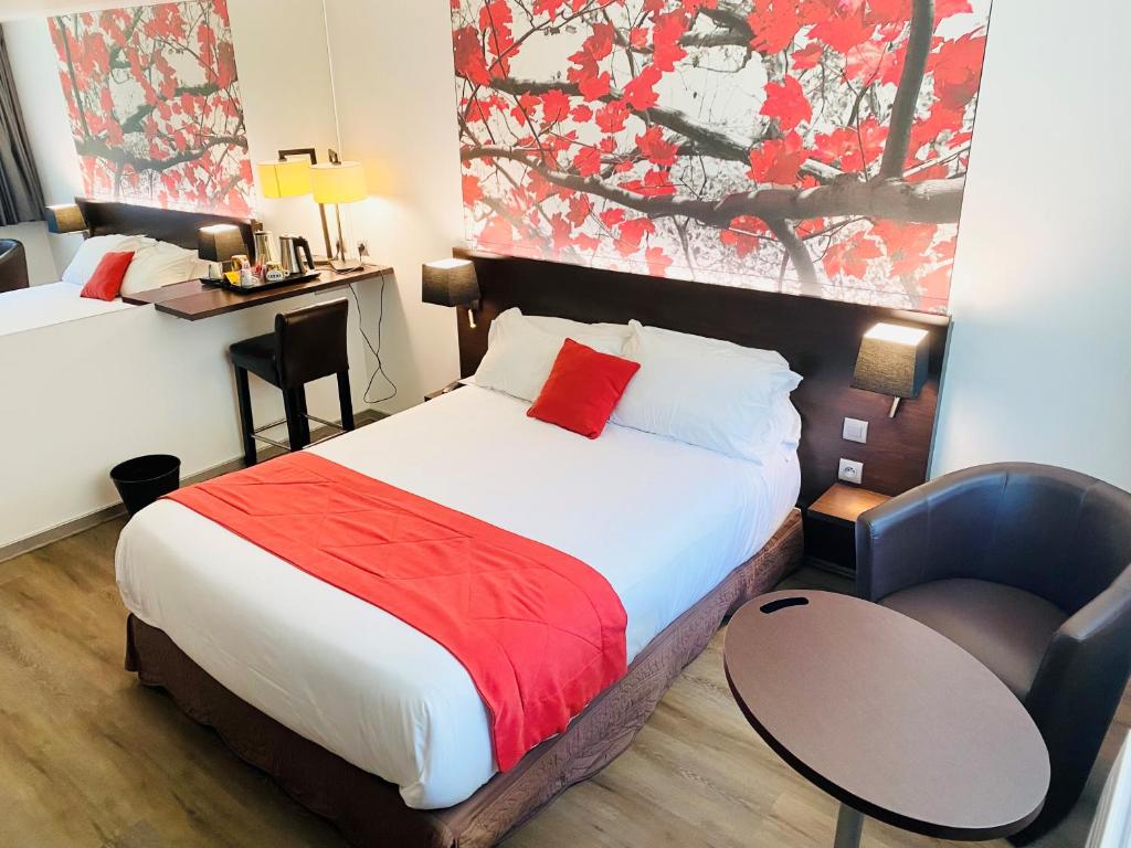 a hotel room with a bed with a red blanket at Hotel Pavillon des Gatines in Plaisir