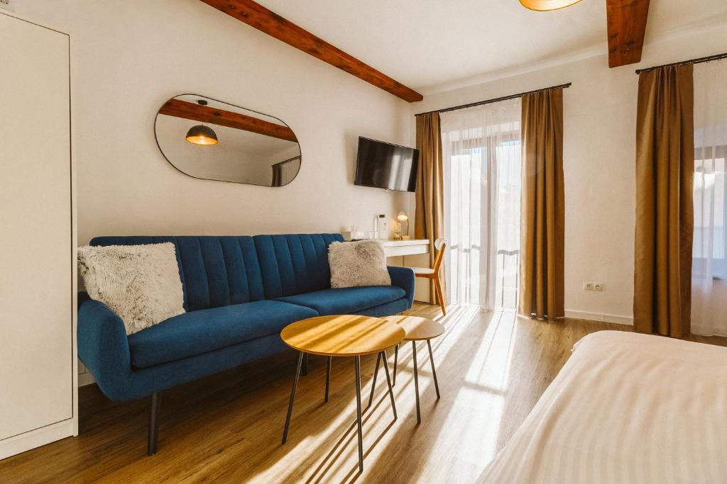 a living room with a blue couch and a table at Townhouse Boutique in Sibiu