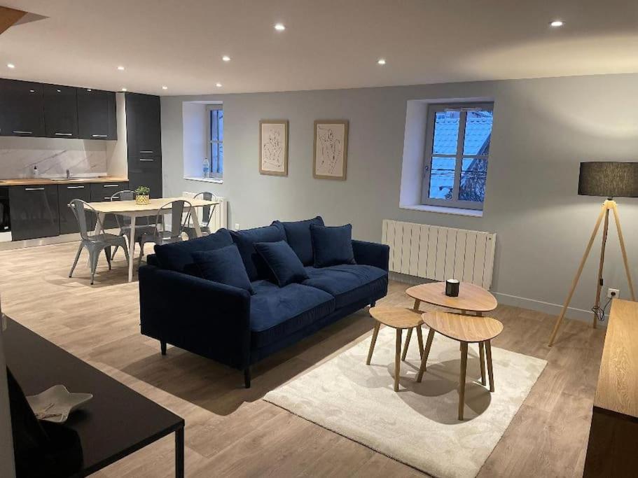 a living room with a blue couch and a table at Appartement plein centre, garage recharge voiture in Langres