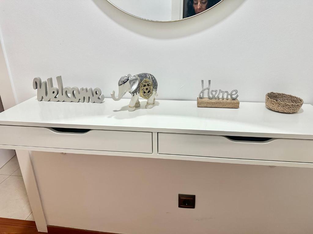 eine weiße Kommode mit einem Elefantenspielzeug darauf in der Unterkunft 10 minutos centro Sevilla, moderno y con parking gratis in Sevilla