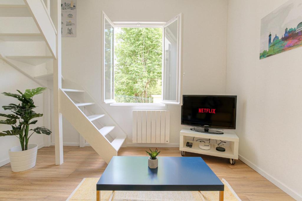 TV a/nebo společenská místnost v ubytování Maison cosy avec terrasse à 15 minutes de Lyon et WIFI